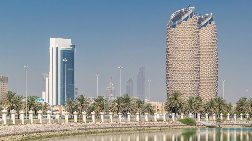 A view of a city with towering buildings and palm trees, showcasing the application of GRC cladding panels.